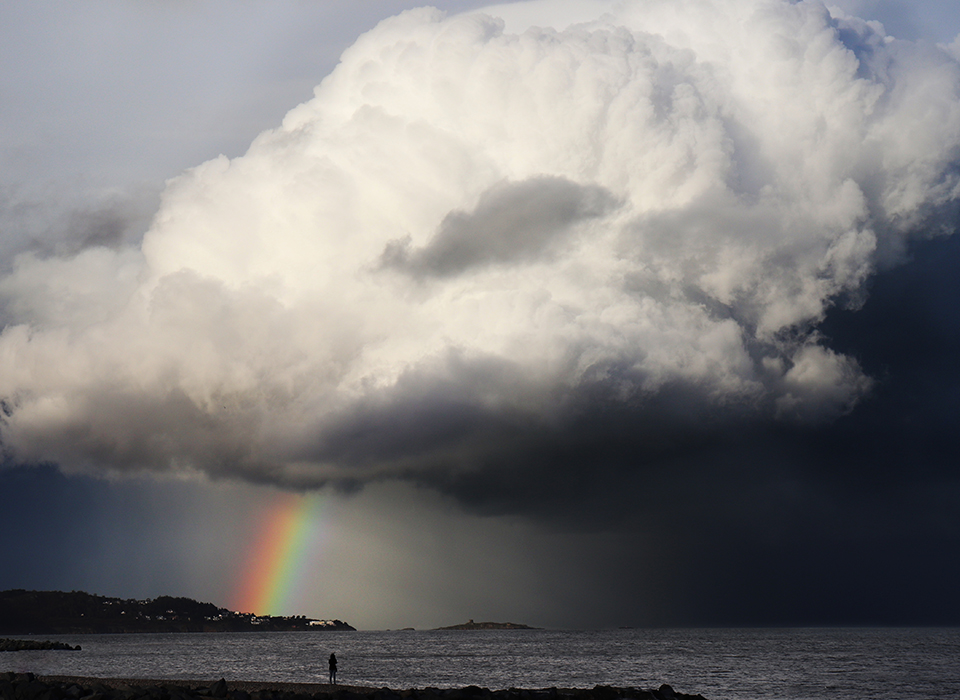 Giant cloud with beautiful rainbow landing on peninsula